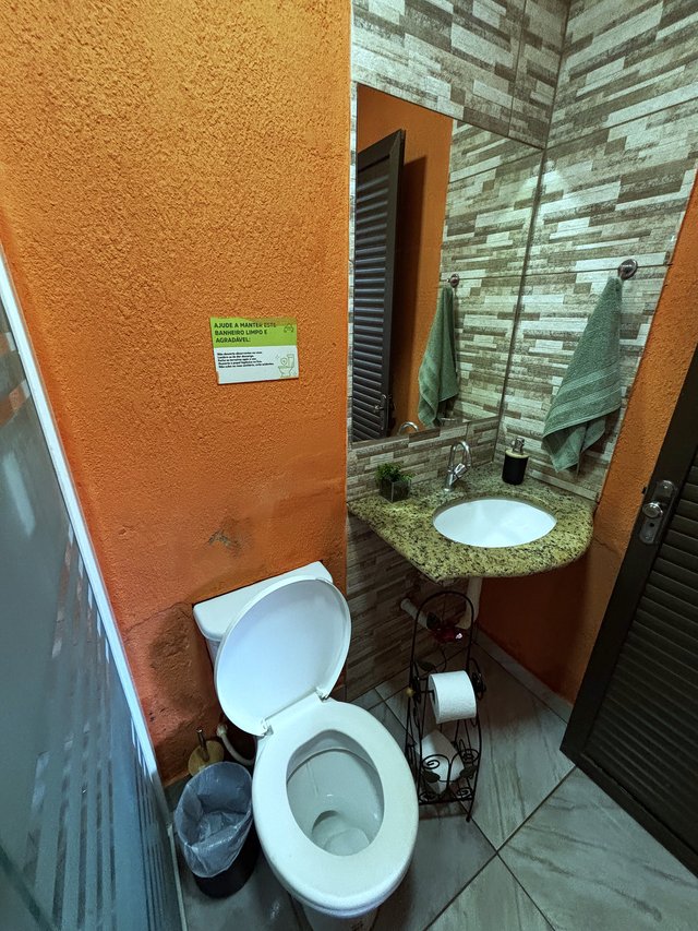 Banheiro — Bancada em granito com parede terracota e revestimento em pedra