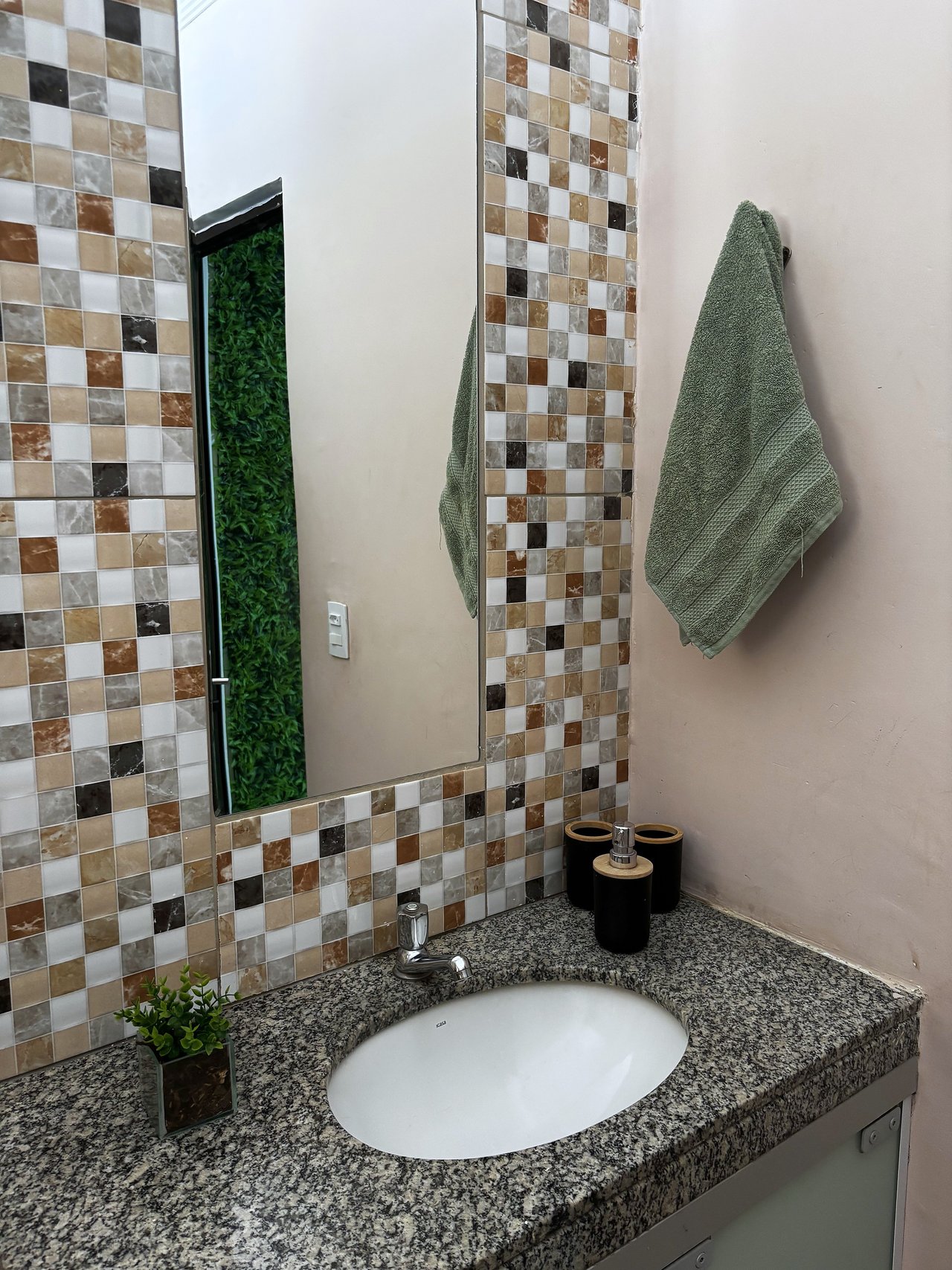 Banheiro — Mosaico marrom com espelho vertical e toalha verde