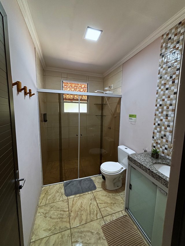 Banheiro — Box espacoso com divisória de vidro e ducha