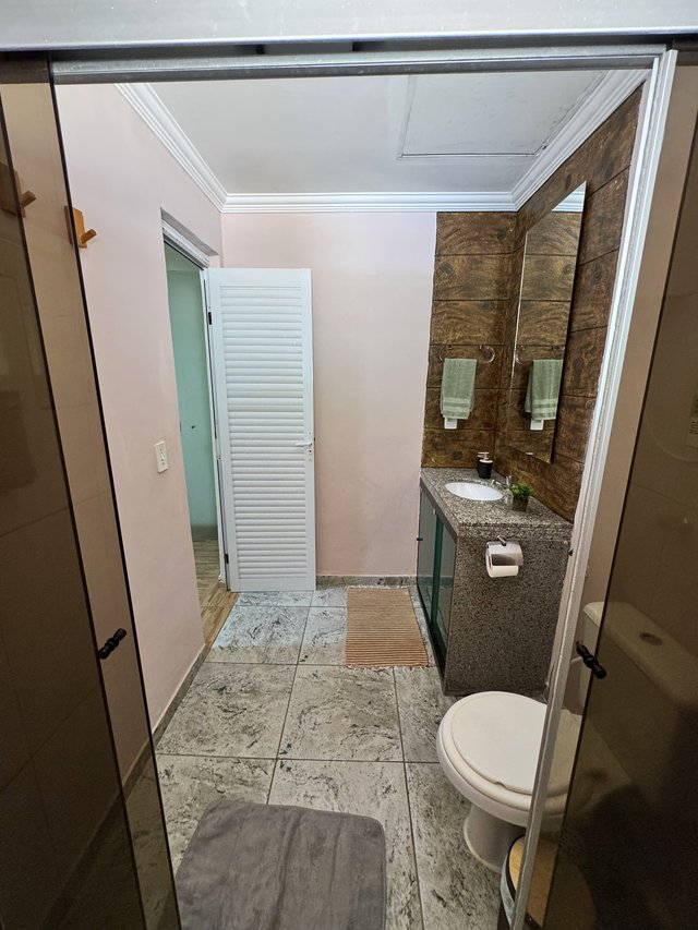 Banheiro — Passagem entre o lavabo e o quarto com porta de madeira