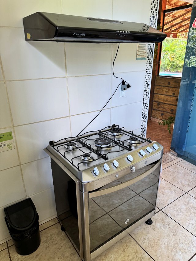 Cozinha — Bancada com utensílios e janela para o quintal