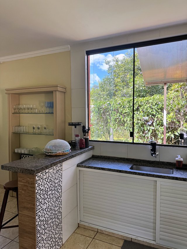 Cozinha — Bancada lateral com utensílios e armários brancos