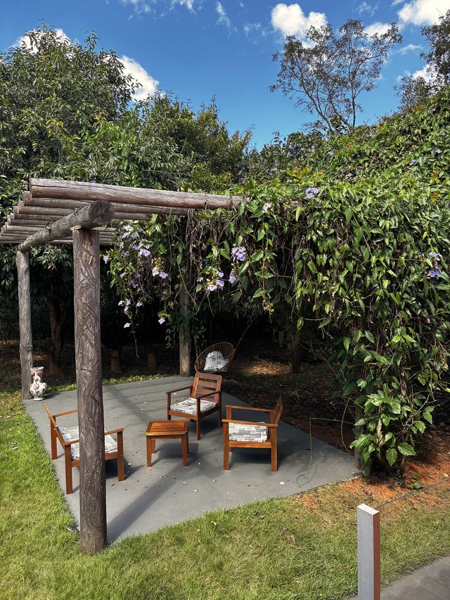 Exterior — Corredor coberto com piso cerâmico e vista para o jardim