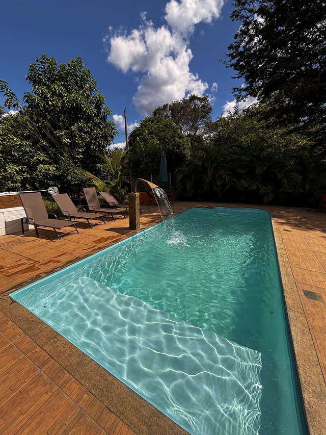 Piscina — Espaço aberto com espreguiçadeiras e ombrelone