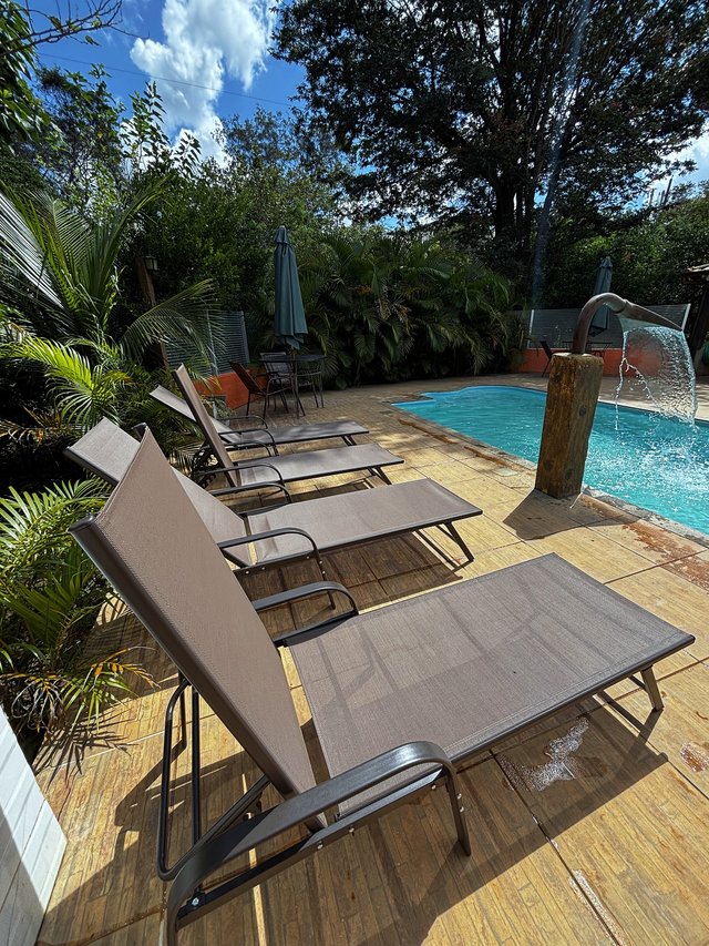 Piscina — Fila de espreguiçadeiras de frente para a piscina
