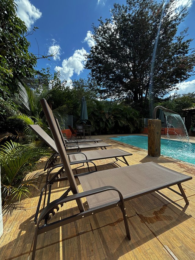 Piscina — Vista da espreguiçadeira com cascata visível
