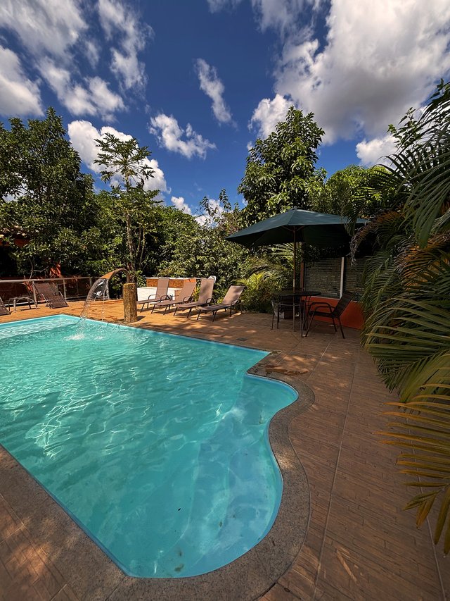 Piscina — Borda com cascata de água iluminada pelo sol