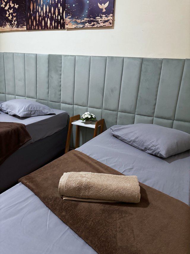 Quarto Azul — Vista da cama com janela ao fundo