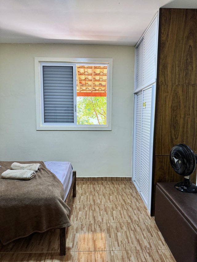 Quarto do Casal — Janela com vista para o telhado e porta do guarda-roupa