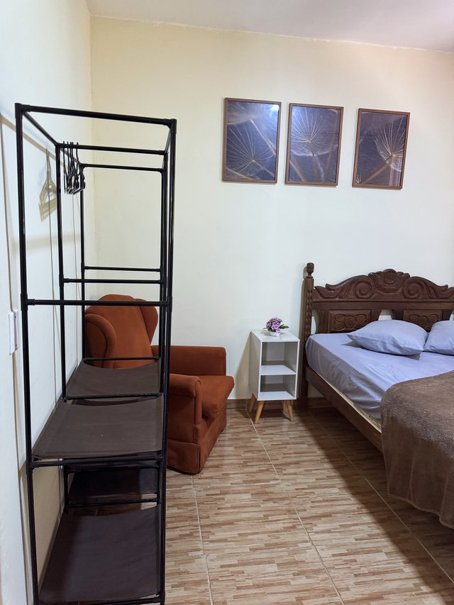 Quarto do Casal — Poltrona terracota ao lado da cama com criado-mudo