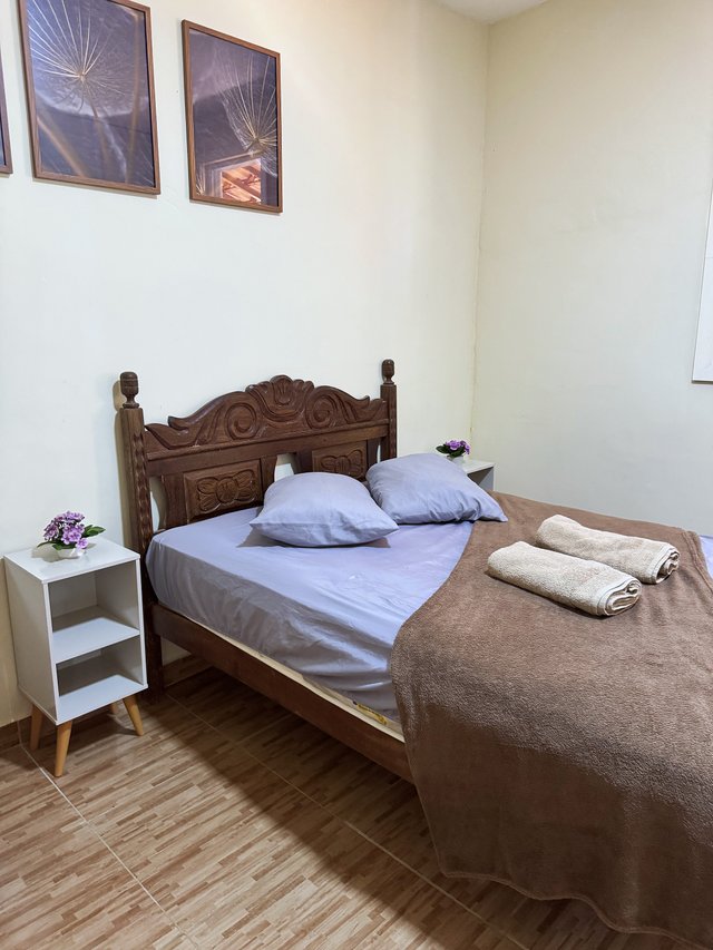 Quarto do Casal — Cama vista de lado, com luminária de cabeceira