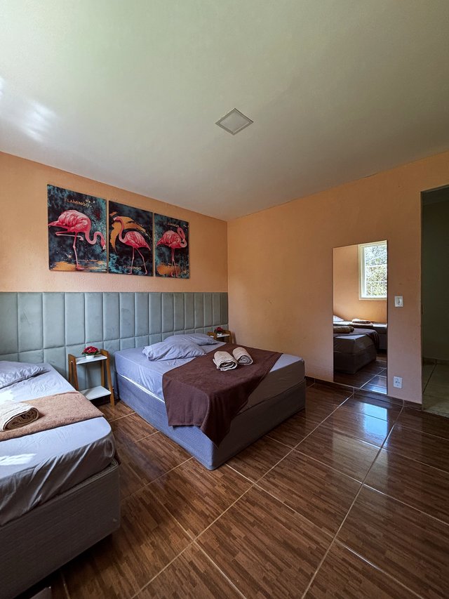 Quarto Flamingo — Janela com cortina e vista para o jardim
