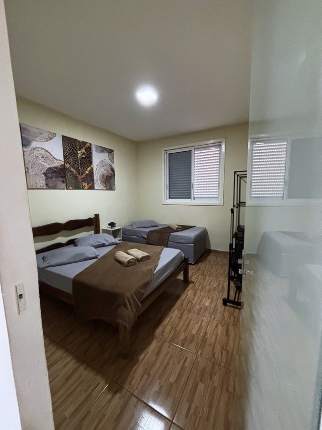 Quarto Rústico — Duas camas com quadros de arte natural sobre cabeceiras