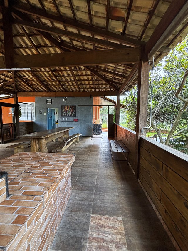 Rancho — Vista lateral, com bancos longos e abertura para a piscina