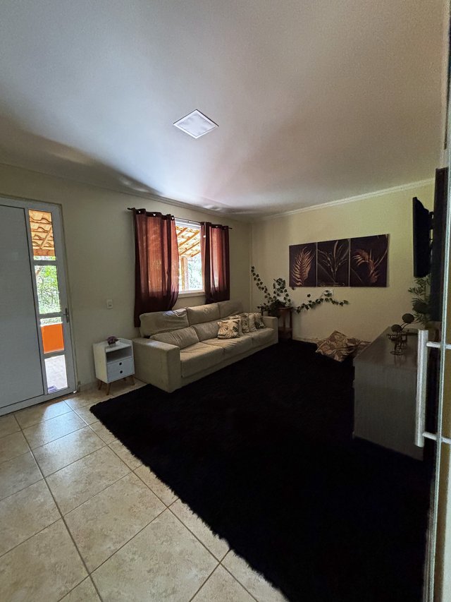 Sala de Estar — Espaço aberto com sofá e janela iluminada