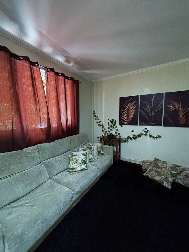 Sala de Estar — Espaço aberto com sofá, almofadas e plantas