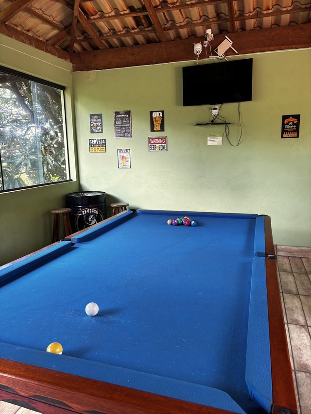 Salão de Jogos — Espaço aberto com pebolim e mesa de sinuca ao fundo