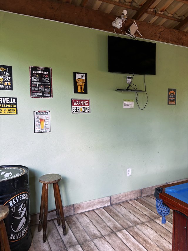 Salão de Jogos — Vista do canto bar com placas decorativas e barril