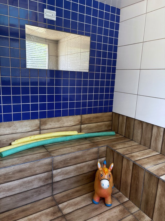 Sauna — Bancada de madeira com revestimento branco e janela com cobogó