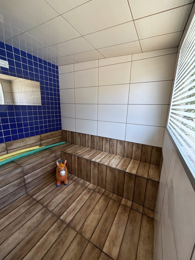 Sauna — Ambiente com parede em mosaico azul e bancada de madeira